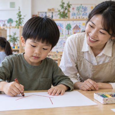 第一條屋頂線：男孩專心畫出屋頂與牆壁，旁邊留著準備畫家人的空間。