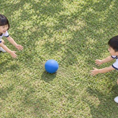 你傳我接：兩名孩子面對面，把藍球慢慢滾給彼此。